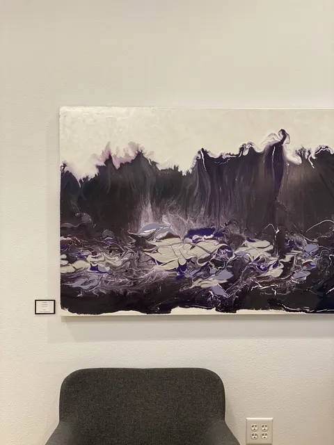 A tall painting by Steve Caldwell in deep purple and cream with a cresting-wave form.